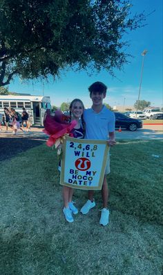 a boy and girl standing in front of a sign