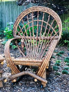 a chair made out of branches sitting on the ground