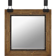 a wooden frame mirror hanging on the wall with two metal hooks and a square glass window