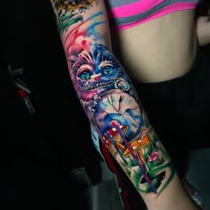 a woman with a colorful tattoo on her arm and clock in the middle of her arm