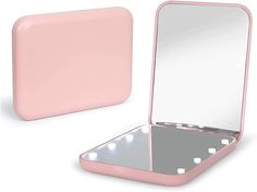 a pink vanity mirror sitting on top of a table next to a light pink case