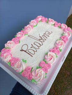 a birthday cake with pink and white frosting roses on the bottom that says grandma