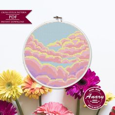 a cross stitch pattern with flowers in front of it