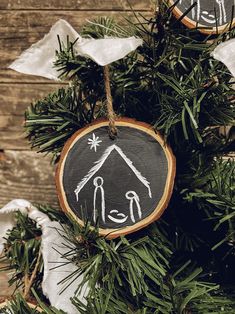 an ornament hanging from a christmas tree decorated with hand painted nativity ornaments