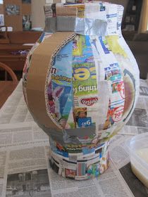 a vase made out of newspaper sitting on top of a table