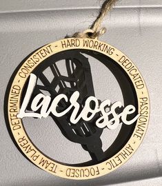 a metal sign that says lacrosse hanging from a rope