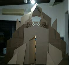 a cardboard castle made to look like it is built into the ground with its door open