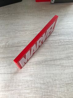 a red marlbau sign sitting on top of a wooden table next to a laptop computer