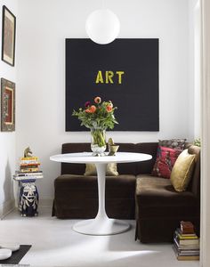 a living room filled with furniture and a painting hanging on the wall above a table