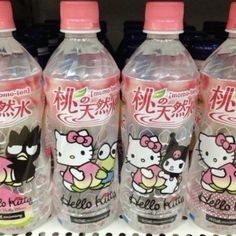 three hello kitty water bottles sitting on a shelf