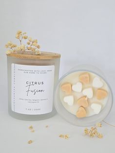 a jar of heart shaped marshmallows next to a candle