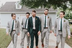 a group of men in suits walking down a sidewalk