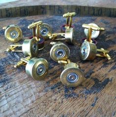 six brass cufflinks on top of a wooden barrel