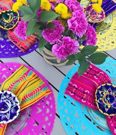 brightly colored plates and flowers on a table