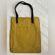 Mustard Yellow Leather Tote Bag With Black Leather Handles. One Exterior Pocket And One Interior Pocket. Made By Sidney Ann. There Are A Few Marks To The Yellow Leather That You Can See In All The Photos. Please Be Sure To Check Them Out Before You Buy. Aside From Those Few Marks, It’s In Great, Nearly Unused Condition. Measurements Are 15.5 X 13.5 With An 8.5” Handle Drop. Yellow Square Satchel For Daily Use, Yellow Square Satchel For Travel, Chic Yellow Square Satchel, Everyday Yellow Square Satchel, Yellow Square Shoulder Bag For Daily Use, Chic Yellow Square Bag, Yellow Square Satchel With Handles, Yellow Square Shoulder Bag With Adjustable Strap, Gold Leather Satchel With Leather Handles