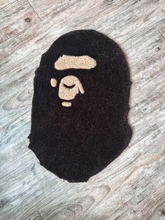 a bathing cap with a gorilla face on the front and side, sitting on top of a wooden floor