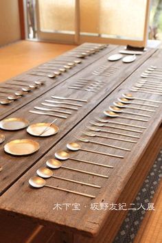 a wooden table topped with lots of silverware on top of it's sides