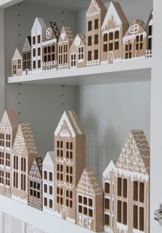 the shelves are made out of cardboard and decorated with gingerbread town houses on them