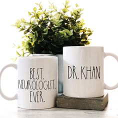 two coffee mugs with the words best neurologist ever and dr khan on them