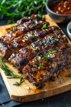 Grilled ribs garnished with herbs on a wooden board, served with a side of sauce. Cuban Mojo Pork, Cuban Pork Sandwich, Cuban Mojo Marinated Pork, Recipes Burgers, Belizean Food, Pork Roast Recipe, Cuban Mojo, Pork Dinners, Cuban Pork