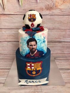 a three tiered cake with a soccer ball on top and an image of barcelona's face