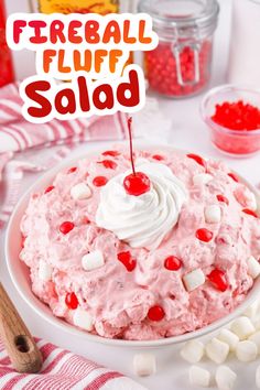 a cake with marshmallows and cherries is on a plate next to candy