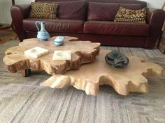 a wooden table sitting on top of a carpeted floor next to a brown couch