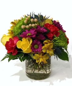 a vase filled with lots of colorful flowers