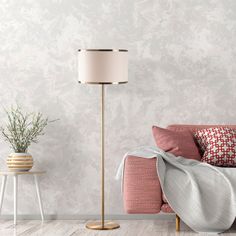 a living room with a pink couch, lamp and table in front of the wall