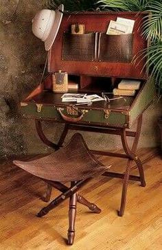 an old fashioned desk and chair in front of a potted plant on the floor