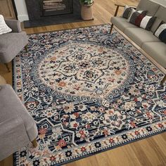 a living room filled with furniture and a rug on top of a hard wood floor