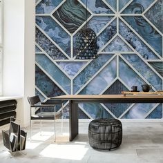 a dining room with a table and chairs in front of a blue mosaic tile wall