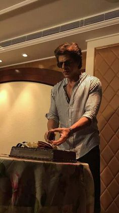 a man standing in front of a table with a cake on it