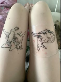 two people with tattoos on their legs, one has a dog and the other has a cat