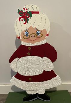 a paper cut out of an old woman wearing glasses and a red dress with a bow on her head