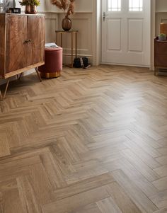 a living room with wood floors and white walls in the background is a large wooden cabinet