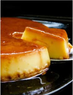 two pieces of cheesecake sitting on top of a pan covered in caramel sauce