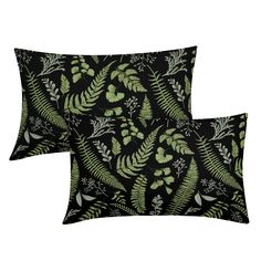 two black and green pillows with leaves on them