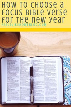 an open bible on a table with a cup of coffee and pen next to it