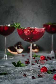 two glasses filled with raspberry martinis and garnished with mint leaves