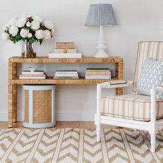 a room with a chair, table and flowers on the shelf in front of it