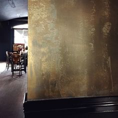 a room with chairs, tables and a wall that has gold paint on the walls