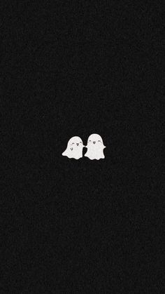 two white ghost heads are in the dark