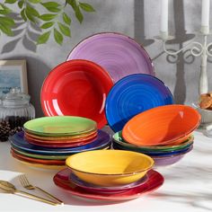 there are many different colored plates on the table