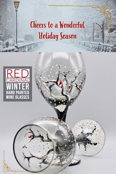 there is a wine glass that has been decorated with snow and red berries on it