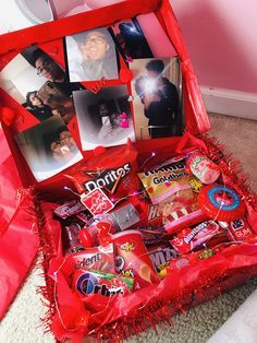 an open valentine's day gift box filled with candies, candy and photos