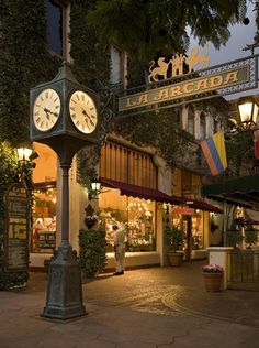 a clock on a pole in front of a building