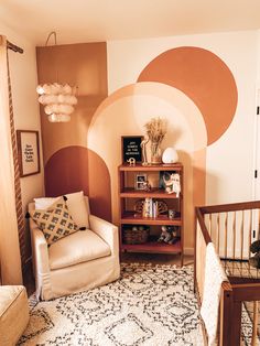 a baby's room with a crib, chair and book shelf in it