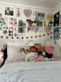 a bed with lots of stuffed animals on the headboard and pillows in front of it