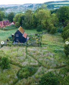 an aerial view of a house in the middle of a field with lots of trees